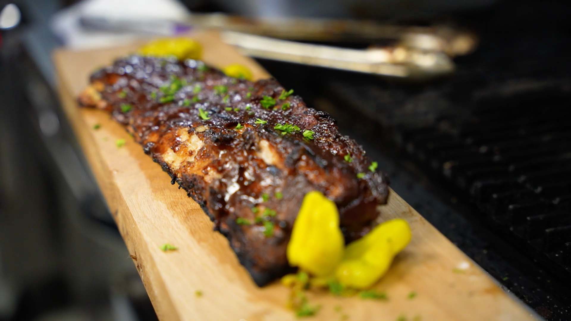 Rack of baby back ribs served on a wood plank