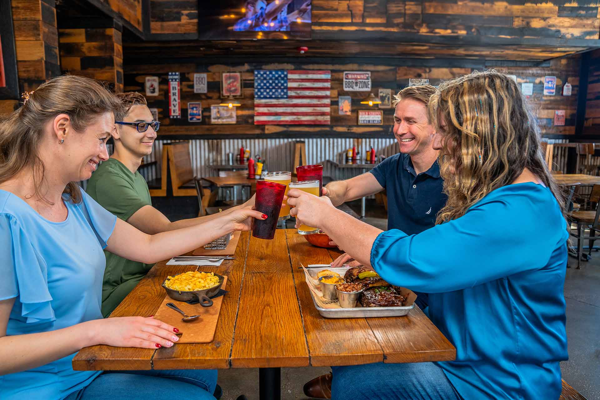 Group of friends toasting their drinks at Lizzie's Memphis Style BBQ restaurant