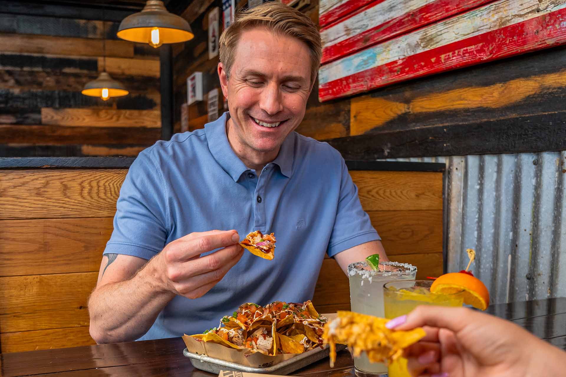 Man eating loaded BBQ nachos at Lizzie's Memphis Style BBQ